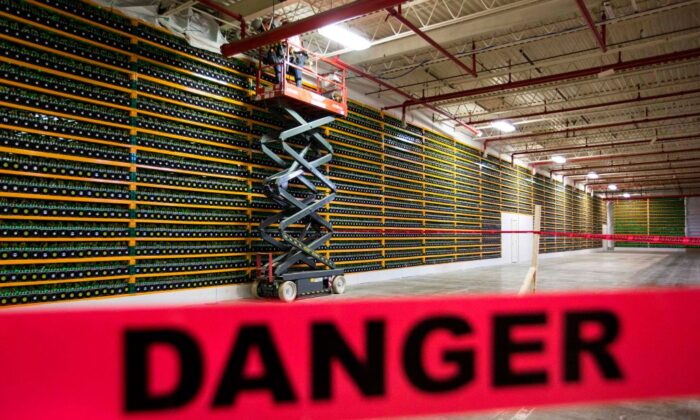 Dos trabajadores de la construcción utilizan un ascensor a lo largo de un muro de minería de bitcoin en Bitfarms en Saint Hyacinthe, Quebec, el 19 de marzo de 2018. (Lars Hagberg/AFP vía Getty Images)