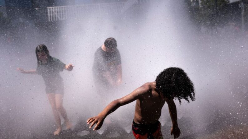 Los niños juegan en la fuente de Salmon Springs en Portland, Oregón, el 27 de junio de 2021. (Nathan Howard/Getty Images)