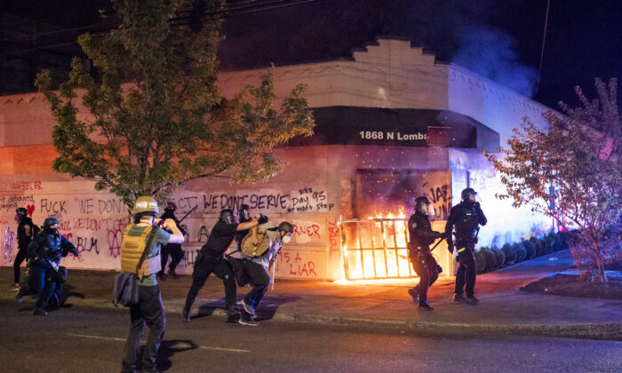 La policía de Portland dispersa a una multitud después de que alborotadores prendieran fuego al edificio de la Asociación de Policía de Portland, en Portland, Oregón, el 29 de agosto de 2020. (Nathan Howard/Getty Images)