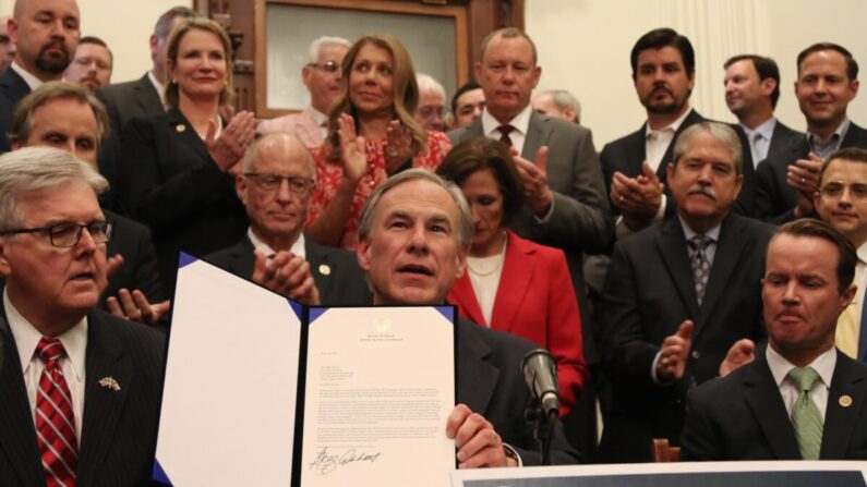 El gobernador de Texas, Greg Abbott, muestra un proyecto de ley que firmó durante una conferencia de prensa en el capitolio estatal en Austin, Texas, el 16 de junio de 2021. (Mei Zhong/The Epoch Times)