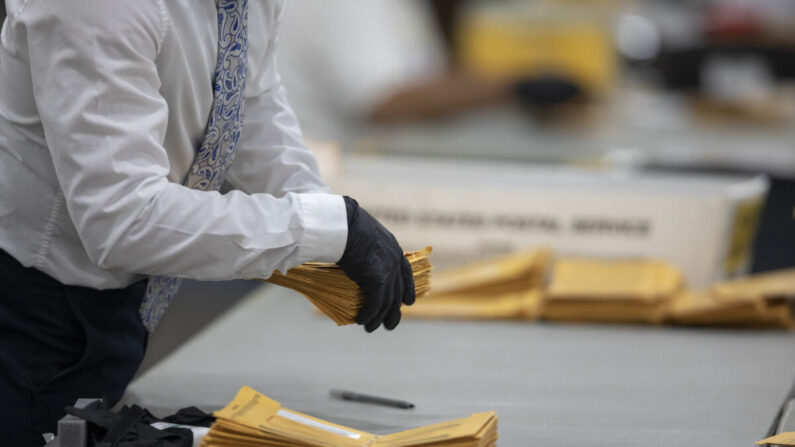 Un trabajador del Departamento de Elecciones de Detroit ayuda a clasificar los votos en ausencia en la Junta Central de Recuento en el Centro TCF en Detroit, Michigan, el 4 de noviembre de 2020. (Elaine Cromie/Getty Images)