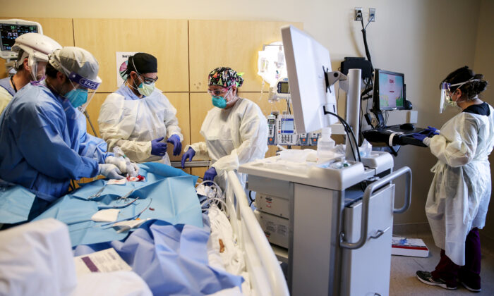 Los médicos realizan una traqueotomía a un paciente en una unidad de cuidados intensivos, en el Centro Médico Providence Holy Cross, en Los Ángeles, California, el 17 de febrero de 2021. (Mario Tama/Getty Images)
