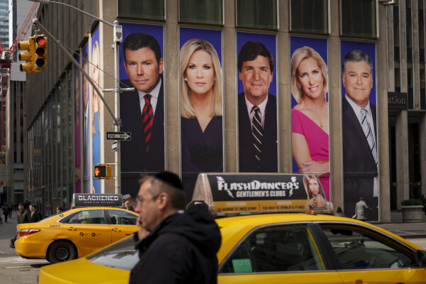 El tráfico en la Sexta Avenida pasa junto a anuncios con personalidades de Fox News, en el edificio de News Corporation, en Nueva York, el 13 de marzo de 2019. (Drew Angerer/Getty Images)
