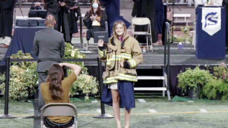Compañeros de bombero que murió en tiroteo en estación de bomberos asisten a graduación de su hija