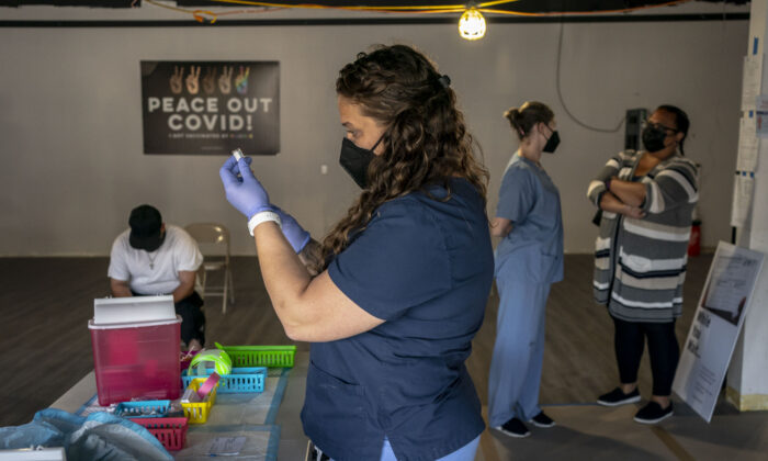 La enfermera, Nicole Warner, prepara dosis de la vacuna anti-COVID durante la jornada de vacunación Joints4Jabs COVID-19, en la tienda de cannabis Uncle Ikes White Center, en Seattle, Washington, el 16 de junio de 2021. (David Ryder/Getty Images)