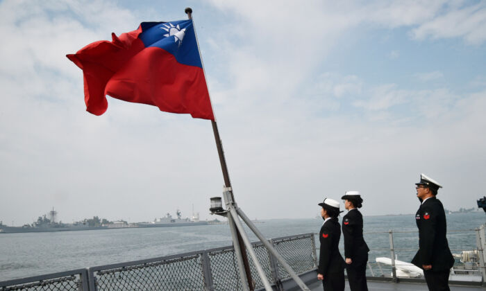 Marineros taiwaneses saludan la bandera de la isla en la cubierta del buque de aprovisionamiento Panshih tras participar en ejercicios militares anuales, en la base naval de Tsoying, en Kaohsiung, Taiwán, el 31 de enero de 2018. (Mandy Cheng/AFP vía Getty Images)