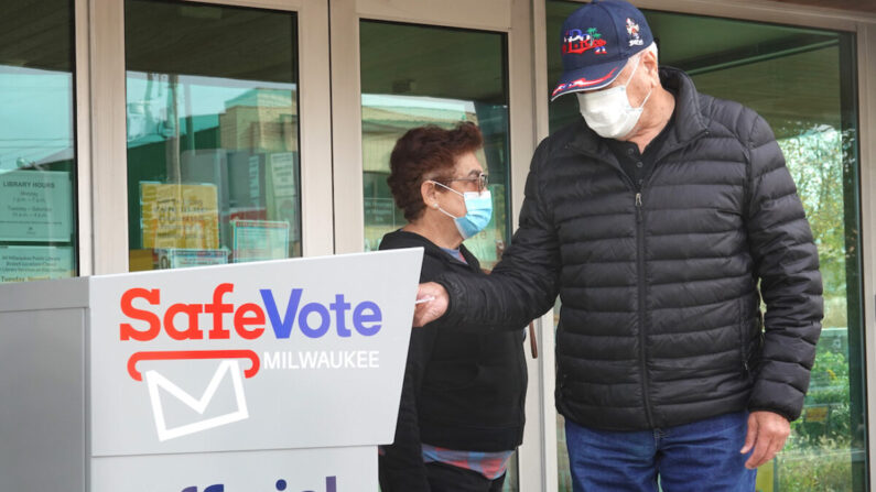 Residentes depositan sus boletas por correo en una urna fuera de la biblioteca sucursal de Tippecanoe en Milwaukee, Wisconsin, el 20 de octubre de 2020. (Scott Olson/Getty Images)