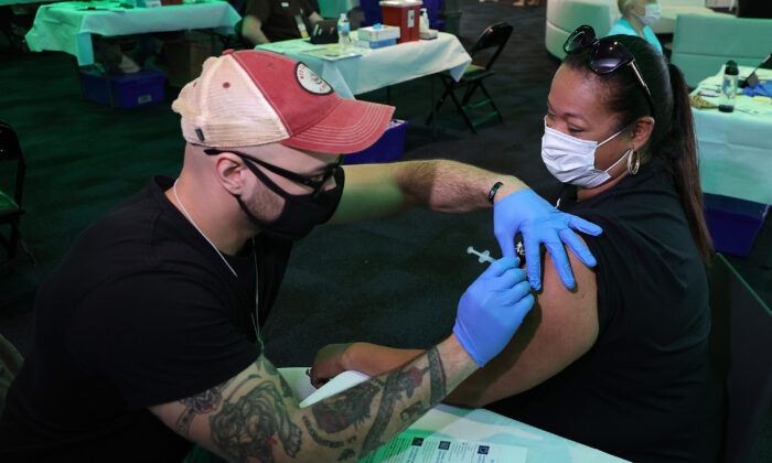 Tina Lopez recibe su primera dosis de la vacuna anti-COVID antes de un juego entre los Milwaukee Bucks y los Brooklyn Nets, en el Fiserv Forum, en Milwaukee, Wisconsin, el 2 de mayo de 2021. (Stacy Revere/Getty Images)
