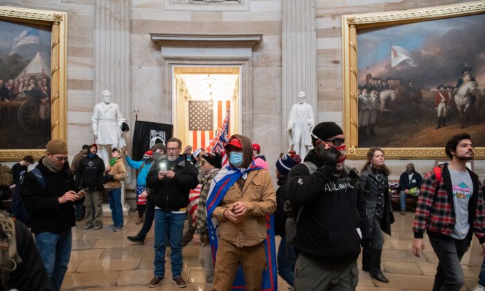 Varios manifestantes caminan por la Rotonda después de irrumpir en el Capitolio de EE. UU. en Washington el 6 de enero de 2021. (Saul Loeb/AFP vía Getty Images)