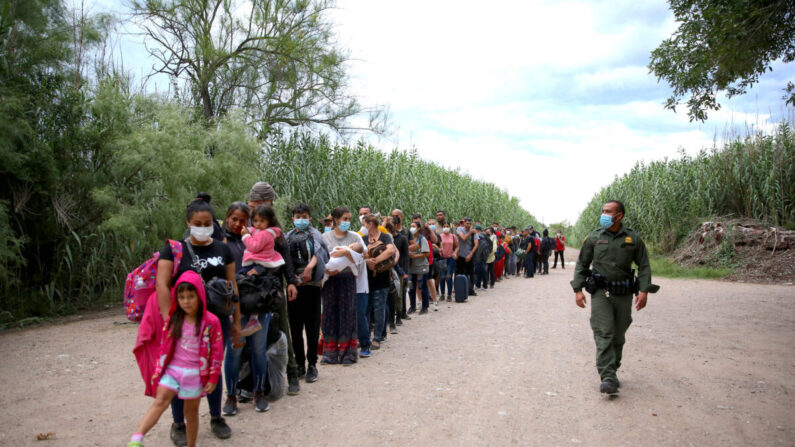 Un grupo de venezolanos espera ser recogido por la Patrulla Fronteriza después de cruzar ilegalmente el Río Grande desde México hacia Del Río, Texas, el 3 de junio de 2021. (Charlotte Cuthbertson/The Epoch Times)