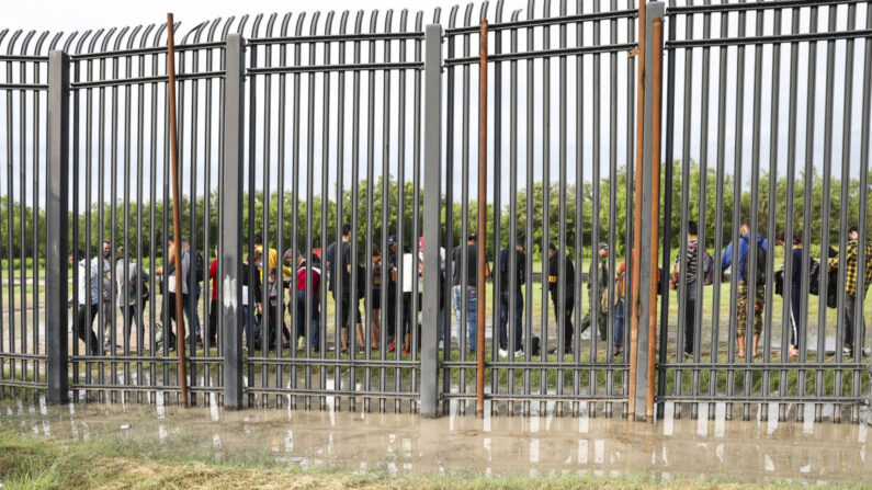 Inmigrantes ilegales esperan a ser recogidos por la Patrulla Fronteriza tras cruzar el Río Grande desde México hasta Del Río, Texas, el 20 de julio de 2021. (Charlotte Cuthbertson/The Epoch Times)