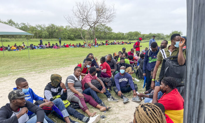 Un grupo de más de 350 inmigrantes ilegales esperan a la Patrulla Fronteriza después de cruzar el Río Grande desde México hacia Del Río, Texas, el 25 de julio de 2021. (Charlotte Cuthbertson/The Epoch Times)