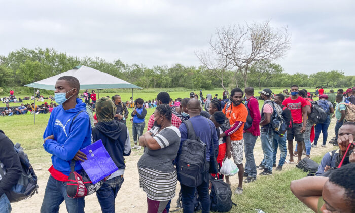 Un grupo de más de 350 inmigrantes ilegales espera a la Patrulla Fronteriza tras cruzar el río Grande desde México hacia Del Río (Texas) el 25 de julio de 2021. (Charlotte Cuthbertson/The Epoch Times)