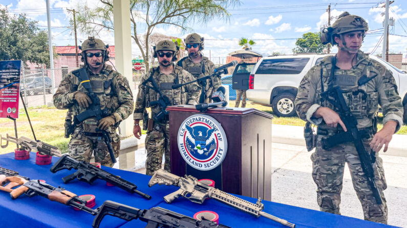 Agentes encargados de hacer cumplir la ley respaldan las armas incautadas con destino a México durante una conferencia de prensa en Laredo, Texas, el 2 de julio de 2021. (Charlotte Cuthbertson/The Epoch Times)