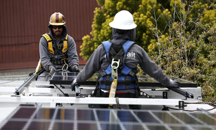 Trabajadores instalan paneles solares en el techo de una casa el 9 de mayo de 2018 en San Francisco, California, el 9 de mayo de 2018. (Justin Sullivan/Getty Images)