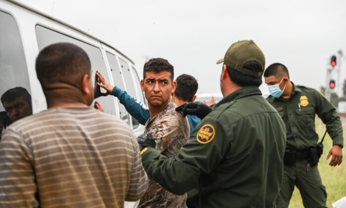 Los agentes de la Patrulla Fronteriza arrestan a extranjeros ilegales de México que se habían escondido en una tolva de granos, en un tren de carga que se dirigía a San Antonio, cerca de Uvalde, Texas, el 21 de junio de 2021. (Charlotte Cuthbertson/The Epoch Times)