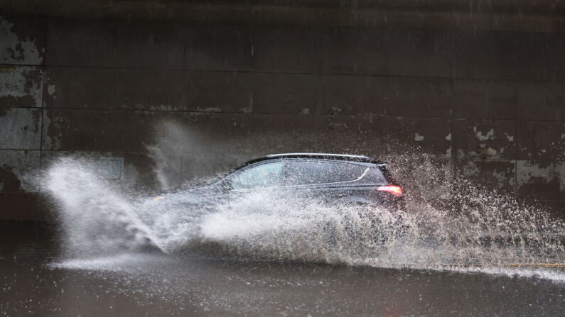 Un coche conduce a través de una ligera inundación en la calle Furman en el barrio de Brooklyn Heights de Brooklyn el 09 de julio de 2021 en la ciudad de Nueva York (EE.UU.). (Michael M. Santiago/Getty Images)