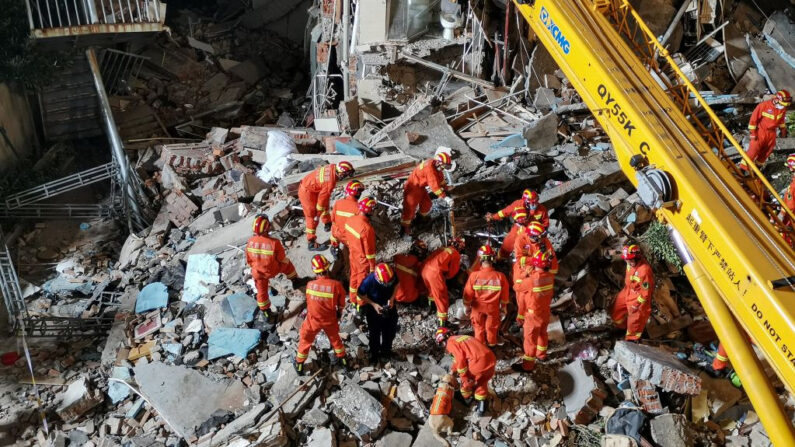 Esta foto tomada el 12 de julio de 2021 muestra a los rescatistas buscando en el sitio de un hotel después de que se derrumbó dejando al menos un muerto y otros 10 desaparecidos en la ciudad de Suzhou en la provincia oriental china de Jiangsu. (CNS/AFP vía Getty Images)