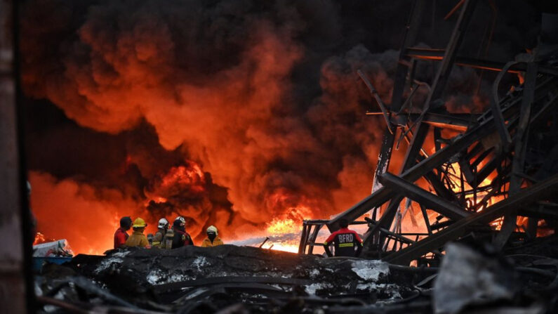 Los bomberos trabajan en el lugar de una explosión e incendio en una fábrica de plásticos en las afueras de Bangkok (Tailandia) el 5 de julio de 2021. (Lillian Suwanrumpha/AFP vía Getty Images)