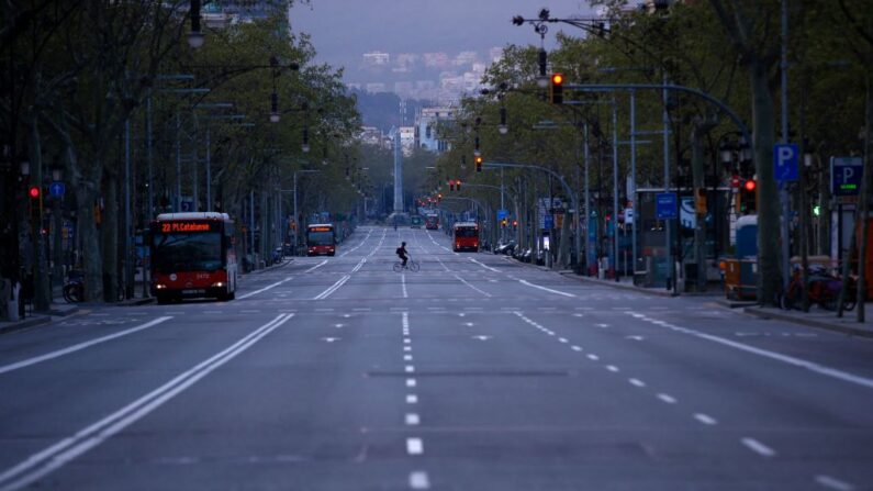 Un ciclista solitario cruza la avenida de Gràcia en Barcelona (España) el 21 de marzo de 2020 durante un cierre nacional por la propagación del covid-19. (Pau Barrena/AFP vía Getty Images)