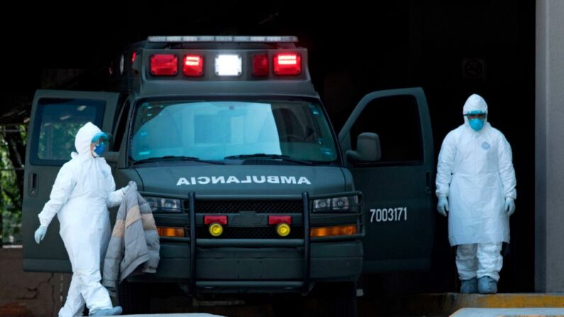 Personal médico lleva trajes de protección junto a una ambulancia en el exterior del Hospital Belisario Domínguez en la Ciudad de México el 05 de mayo de 2020. (Claudio Cruz/AFP vía Getty Images)