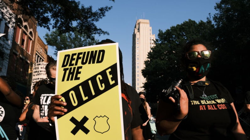 Una manifestante lleva un cartel que dice "Desfinanciar a la policía" durante la marcha "Say Her Name", de Black Women Matter, el 3 de julio de 2020 en Richmond, Virginia. (Eze Amos/Getty Images)