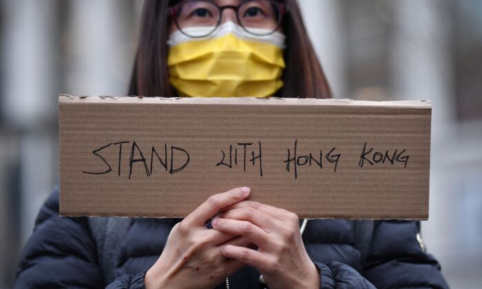 Un manifestante sostiene una pequeña pancarta en un acto organizado por Justitia Hong Kong para lamentar la pérdida de las libertades políticas de Hong Kong, en Leicester Square, en el centro de Londres, el 12 de diciembre de 2020. (Justin Tallis/AFP vía Getty Images)