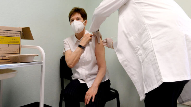Adrienne Kertesz, médico del Hospital Central del Sur de Pest, recibe la primera vacuna contra el nuevo coronavirus (Covid-19) de Pfizer y BioNTech, de manos del infectólogo jefe Janos Szlavik en el Hospital Central del Sur de Pest en Budapest el 26 de diciembre de 2020. (Foto de SZILARD KOSZTICSAK/POOL/AFP a través de Getty Images)