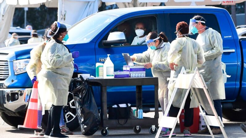 La gente se acerca en sus vehículos para recibir las vacunas contra covid-19 en el aparcamiento de The Forum en Inglewood, California (EE.UU.), el 19 de enero de 2021. (Frederic J. Brown/AFP vía Getty Images)