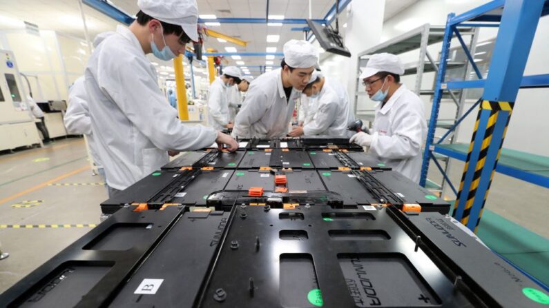 Trabajadores de una fábrica de Xinwangda Electric Vehicle Battery Co. Ltd, que fabrica baterías de litio para coches eléctricos y otros usos, en Nanjing, en la provincia oriental china de Jiangsu. (STR/AFP vía Getty Images)