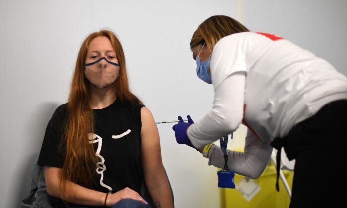 Aplicación de una dosis de la vacuna anti-COVID de Pfizer dentro de un centro de vacunación temporal establecido en el Emirates Stadium, sede del club de fútbol Arsenal, en el norte de Londres, el 25 de junio de 2021. (Daniel Leal-Olivas/AFP vía Getty Images)