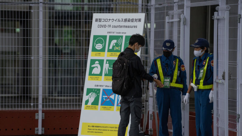 Un hombre se toma la temperatura por un guardia de seguridad al entrar en el Centro Principal de Prensa de los Juegos Olímpicos de Tokio (MPC) el 2 de julio de 2021 en Tokio, Japón. (Carl Court/Getty Images)