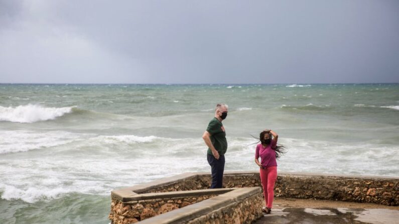 Dos personas observan el fuerte oleaje durante el paso de la tormenta Elsa en el Malecón de Santo Domingo (República Dominicana) el 3 de julio de 2021. (Erika Santelices/AFP vía Getty Images)