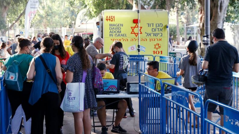 Jóvenes israelíes llegan para recibir una dosis de la vacuna contra covid-19 de Pfizer/BioNTech del Magen David Adom durante una campaña del Ayuntamiento de Tel Aviv-Yafo para fomentar la vacunación de los adolescentes, el 5 de julio de 2021, en Tel Aviv (Israel). (Jack Guez/AFP vía Getty Images)