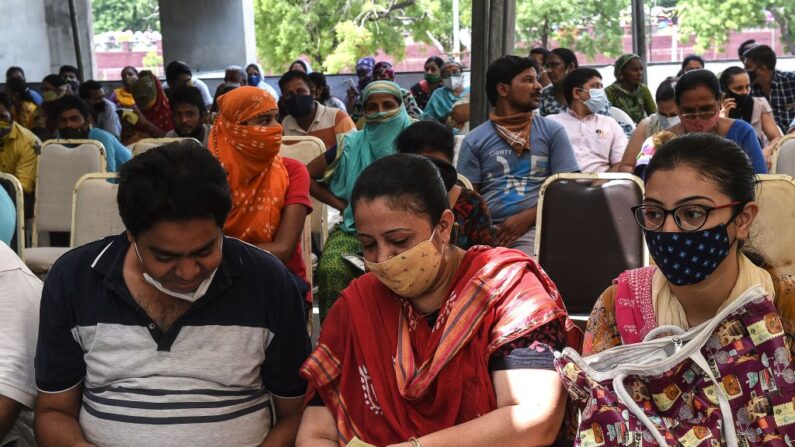La gente espera su turno para recibir una dosis de la vacuna Covishield contra el covid-19 durante una campaña de vacunación en el Tagore Hall de Ahmedabad (India) el 6 de julio de 2021. (Sam Panthaky/AFP vía Getty Images)