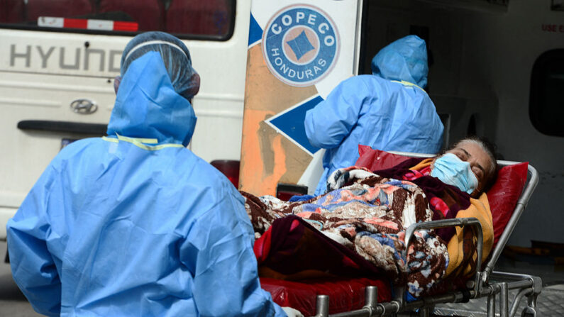 Trabajadores de salud del Comité Permanente de Contingencia (COPECO) transportan a una mujer infectada con COVID-19 al Hospital General San Felipe en Tegucigalpa (Honduras), el 6 de junio de 2021. (Orlando Sierra/AFP vía Getty Images)