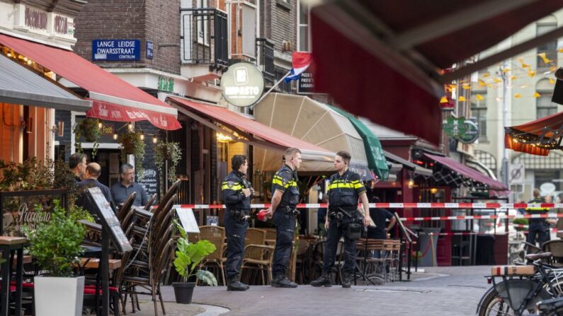 Agentes de policía investigan la calle Lange Leidsedwarsstraat, lugar en el que un periodista holandés especializado en crímenes, Peter R. de Vries, resultó gravemente herido en un tiroteo en Ámsterdam (Países Bajos), el 6 de julio de 2021. (Evert Elzinga/ANP/AFP vía Getty Images)