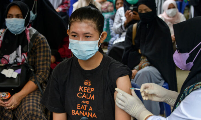 Una mujer recibe una dosis de la vacuna Sinovac durante una campaña de vacunación contra el coronavirus Covid-19 en Banda Aceh, Indonesia, el 7 de julio de 2021. (Chaideer Mahyuddin/AFP vía Getty Images)