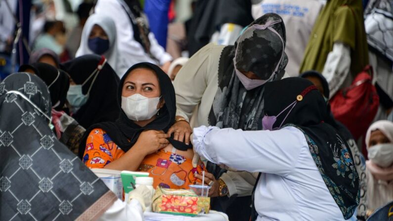 Una mujer recibe una dosis de la vacuna contra el covid-19 de Sinovac durante una campaña de vacunación en Banda Aceh (Indonesia) el 7 de julio de 2021. (Chaideer Mahyuddin/AFP vía Getty Images)