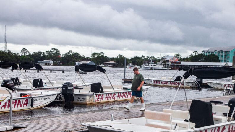 Kyle Raison camina a lo largo del muelle en el Sea Hag Marina mientras los barcos de alquiler de vieiras están atados después de que la tormenta tropical Elsa tocó tierra cerca el 7 de julio de 2021 en Steinhatchee, Florida (EE.UU.). (Mark Wallheiser/Getty Images)