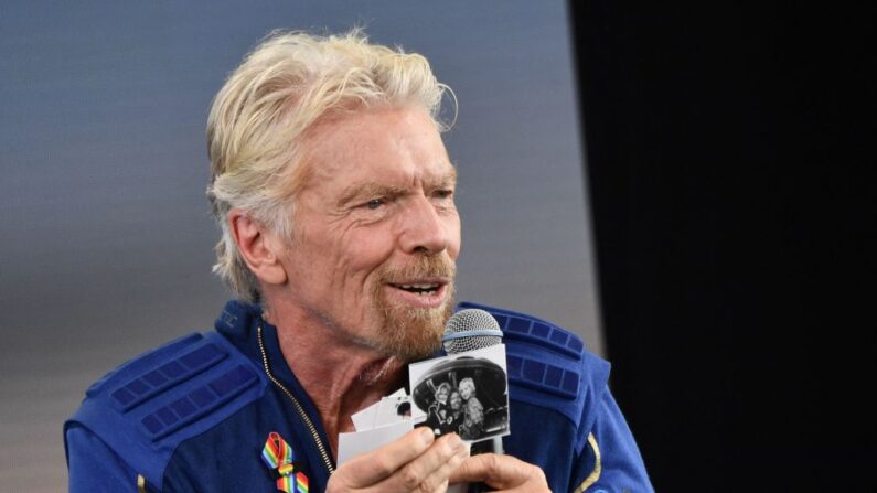 Sir Richard Branson sostiene fotos que trajo consigo al espacio, mientras habla después de volar al espacio a bordo de una nave de Virgin Galactic, en Spaceport America, cerca de Truth and Consequences, Nuevo México, el 11 de julio de 2021. (PATRICK T.FALLON/AFP a través de Getty Images)