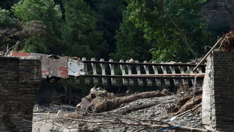 Escombros y árboles arrancados cuelgan sobre las vías del tren dañadas en la ciudad de Altenahr, Renania-Palatinado, oeste de Alemania, el 19 de julio de 2021, tras las devastadoras inundaciones que afectaron a la región. (Christof Stache/AFP vía Getty Images)