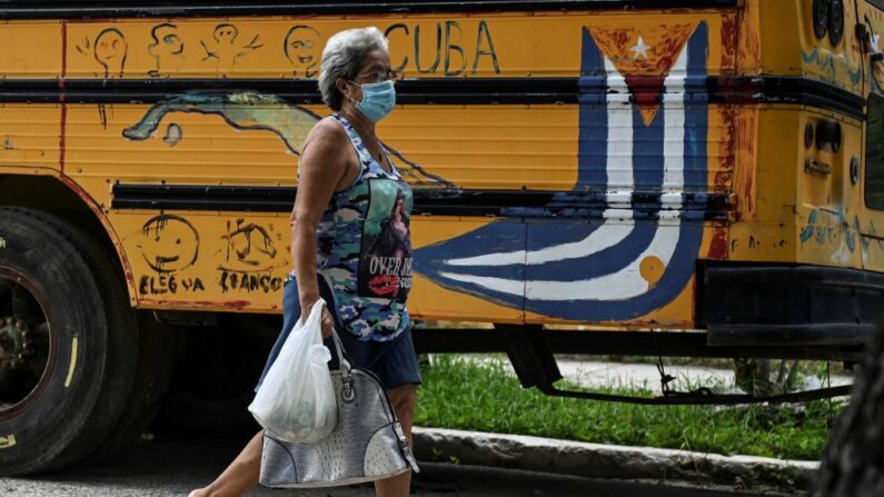 Una mujer pasa junto a un grafiti de la bandera cubana en un autobús en La Habana, el 19 de julio de 2021. (Foto de YAMIL LAGE/AFP a través de Getty Images)