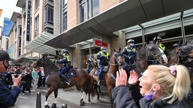 Oficiales de policía a caballo dispersan a los manifestantes durante una manifestación en Sídney, Australia, el 24 de julio de 2021, cuando miles de personas se reunieron para manifestarse contra las órdenes de permanecer en casa durante un mes de la ciudad. (Steven Saphore/AFP vía Getty Images)