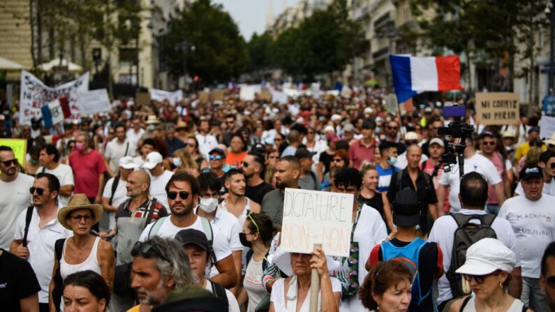 Un manifestante sostiene una pancarta en la que se lee "Dictadura, no y no" durante una manifestación contra la vacunación obligatoria para ciertos trabajadores y el uso obligatorio de la tarjeta sanitaria convocada por el Gobierno francés, en Marsella, sur de Francia, el 24 de julio de 2021. (Clement Mahoudeau/AFP vía Getty Images)