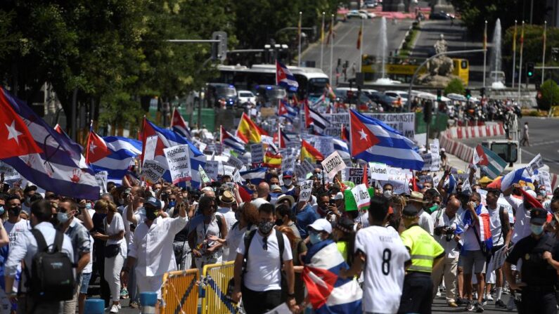 Manifestantes con banderas cubanas marchan por la avenida Gran Vía de Madrid (España) el 25 de julio de 2021 en apoyo a las protestas contra el régimen comunista que se llevaron a cabo en Cuba. (Pierre-Philippe Marcou/AFP vía Getty Images)