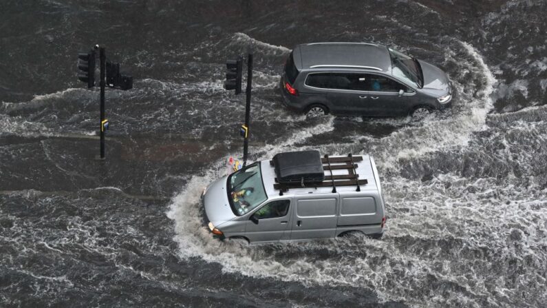 Vehículos conducen a través de agua profunda en una carretera inundada en el distrito de Nine Elms de Londres (Inglaterra) el 25 de julio de 2021 durante las fuertes lluvias. (Justin Tallis/AFP vía Getty Images)