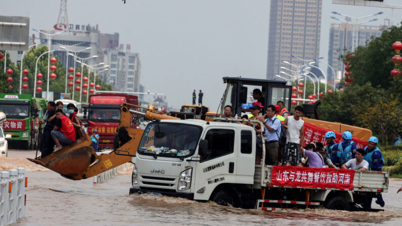 Esta foto tomada el 26 de julio de 2021 muestra a los rescatistas evacuando a los residentes con un camión en una zona inundada en Weihui, ciudad de Xinxiang, en la provincia central china de Henan. (STR/AFP vía Getty Images)