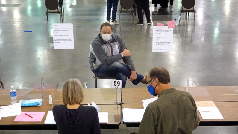 Un observador observa cómo los funcionarios electorales comienzan el proceso de recuento de votos de las elecciones del 3 de noviembre en el Centro de Wisconsin el 20 de noviembre de 2020 en Milwaukee, Wisconsin. 