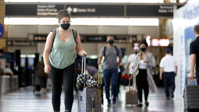 Viajeros caminan con su equipaje en el Aeropuerto Nacional Ronald Reagan de Washington el 25 de mayo de 2021 en Arlington, Virginia (EE.UU.). (Alex Wong/Getty Images)